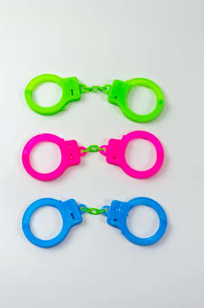 The toy handcuffs are available in green, pink and blue. On a white background.の写真素材
