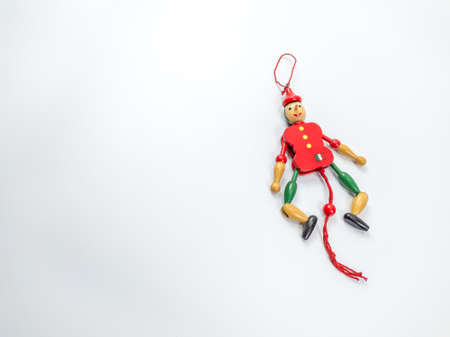 The wooden doll toy has a red-green color on a white background.の写真素材