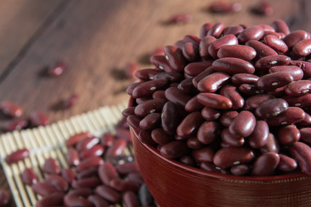 Red beans in a cup on a wooden floor.