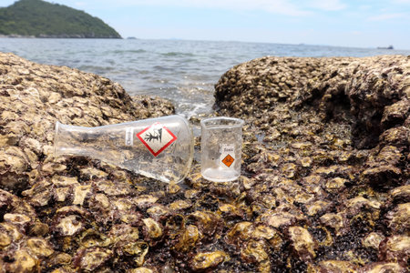 Hazardous chemical waste from the industry on rocks near the sea