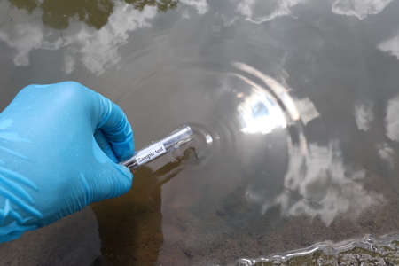 Collect samples of wastewater from industrial canals in test tubes to be examined in the laboratoryの写真素材