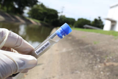 Collect samples of wastewater from industrial canals in test tubes to be examined in the laboratoryの写真素材