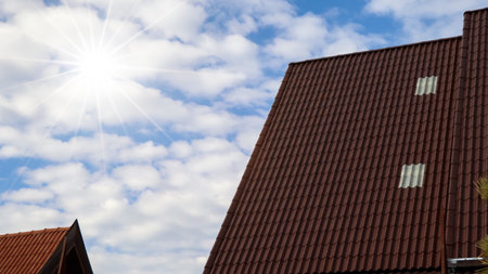 Sun over the roof of the house and blue skyの写真素材