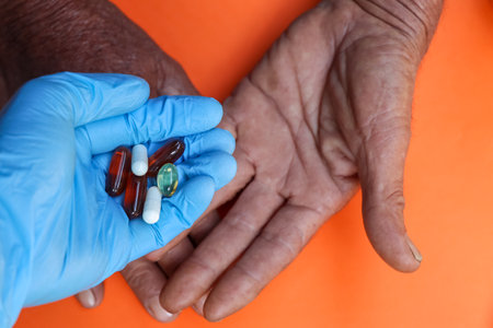 Asian elderly holding pill drug in hand, strong healthy medical conceptの写真素材