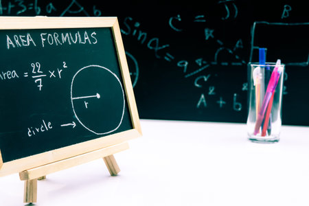 Blackboard with hand written geometry area formulas and geometric shapes and figures