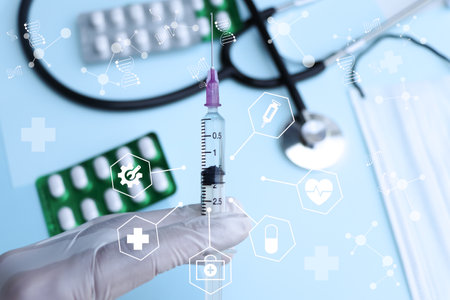 pill on blue background and syringe, medicine for treatmentの写真素材