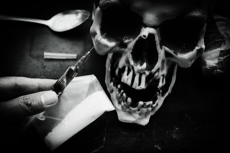 Heroin liquid and heroin powder on a skull background, concept of a narcotic substanceの写真素材