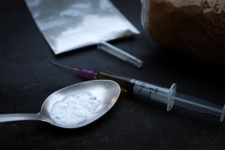 Heroin liquid and heroin powder on a black background, concept of a narcotic substanceの写真素材