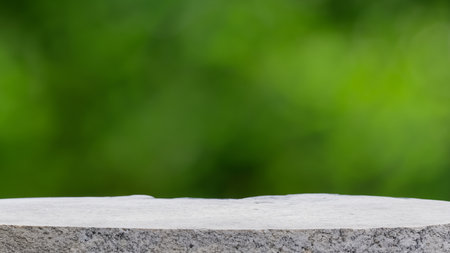 Empty stone table top on blur green nature bokeh background, product displayの写真素材