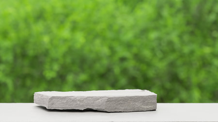 3d render of a stone podium on a green blurred background.の写真素材