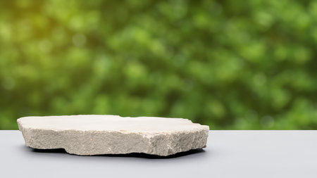 Empty stone podium on green nature bokeh background for product displayの写真素材