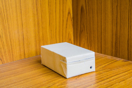 Brown milk carton is crumple On Wood background
