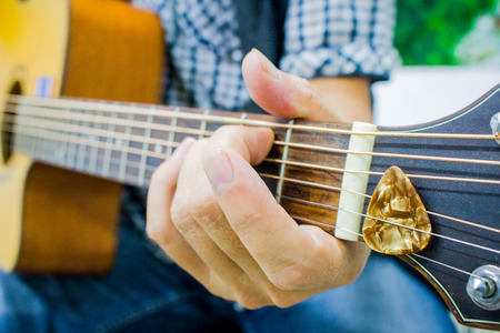 man hand playing guitar, Acoustic guitar in hands, close-upの写真素材