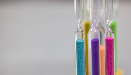 Close up Multi color hourglass clock. concept for business deadline, urgency and running out of time with copy spaceの写真素材