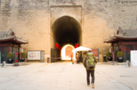 Blurry image Rear view of Male travelers walking The Old Wall Gate texture. Abstract backgroundの写真素材