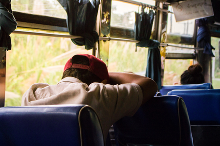 Man fell asleep on seat of the bus during the day with copy spaceの写真素材