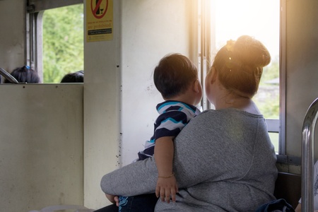 Mother holding a child on On the train Looking out the windowのeditorial素材