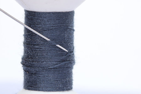 Close up needle and thread  on white background