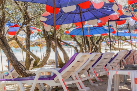 white beach chair and colorful umbrellaの写真素材