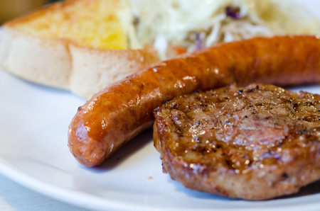 dinner set with pork steak sausage and garlic breadの写真素材