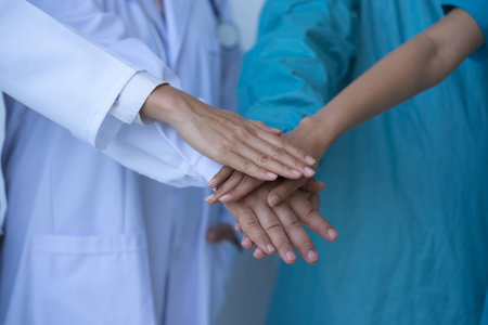 Cooperation of doctors and nurses in a medical team stacking hands.の写真素材