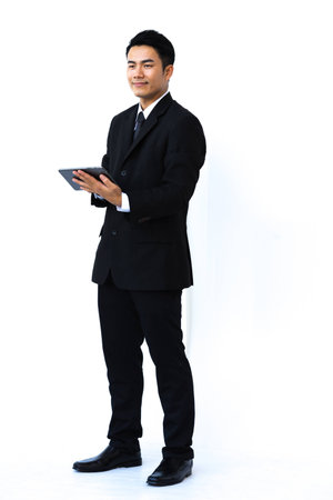 Handsome businessman looked to the side and use the tablet on white background.の写真素材