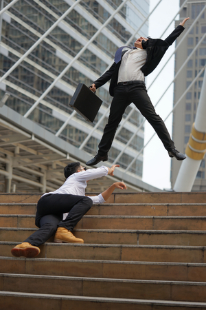 Businessman in suit jumping holding document bag feeling happy when he success and another...