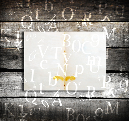 Old open book with falling letters on dark abstract backgroundの写真素材