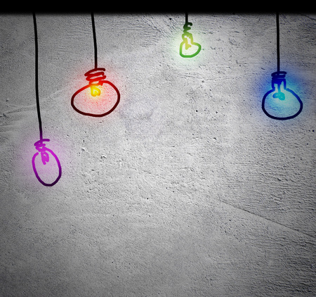 Idea concept with colorful bulbs hanging on the old grunge wall backgroundの写真素材
