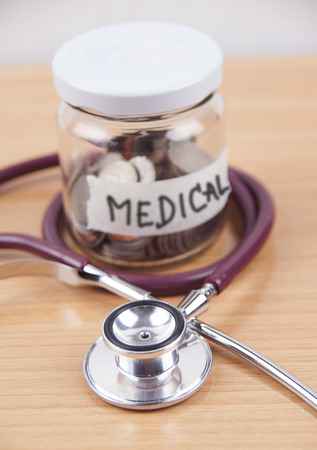 Bottles of coins for Health care cost savingの写真素材