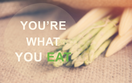 The text You're what you eat on Fresh asparagus prepare on gunny-bag backgroundの写真素材
