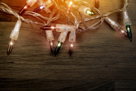 Christmas lights on wooden background with vintage style.