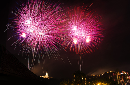 Colorful fireworks explosion with aerial view of buddha temple on the mountain backgroundの写真素材