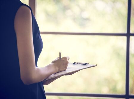 Secretary writing a note in meeting roomの写真素材