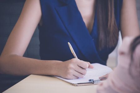Secretary writing a note in meeting roomの写真素材