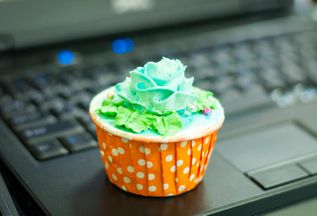 Green cream cupcake on Notebookの写真素材