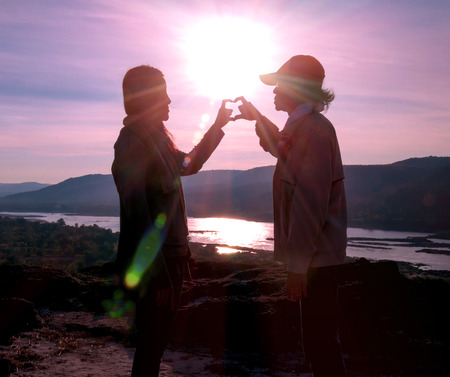 Silhouette of the lover standing on the hilltop during sunrise.