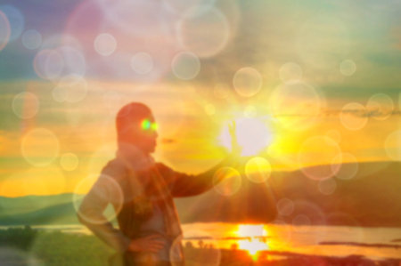 Abstract Blurred and soft photo of Women on hilltop with bokeh of sunrise on the natural backgroundの写真素材