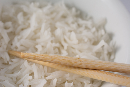 Close Up Detail View of Bowl of White Rice With Wooden Chopsticksの写真素材