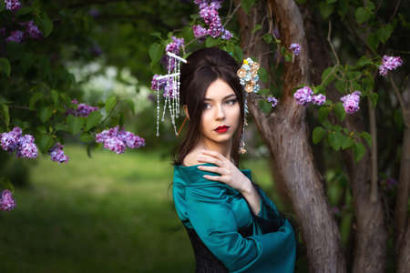 Beautiful asian geisha girl portrait outdoors in park in summerの写真素材
