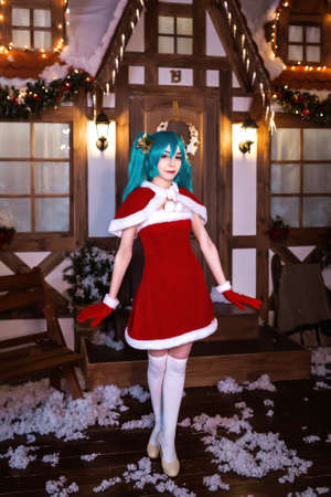 Cute girl cosplaying Christmas  Santa dress around decorationsの写真素材