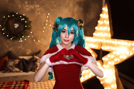 Cute girl cosplaying Christmas  Santa dress around decorationsの写真素材
