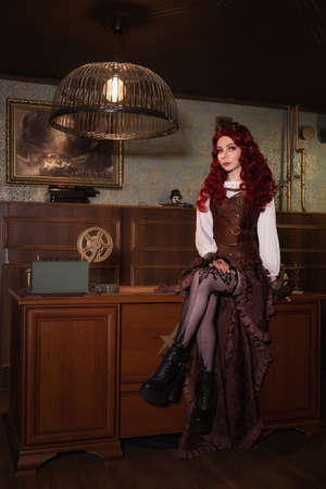 Young attractive vintage steampunk girl indoors sittingの写真素材