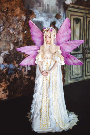 Young attractive girl dressed as fairy in the room aloneの写真素材