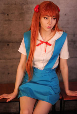 Young attractive girl in blue school uniform japanese style cosplay portrait sitting on benchの写真素材