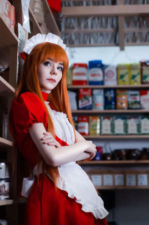 Pretty young girl servant costume portrait dressed in red role play in the shopの写真素材