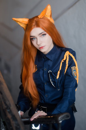 Young atteractive girl dressed as police oficer costume smiling with a cup outdoors