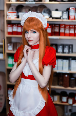 Pretty young girl servant costume portrait dressed in red role play in the shopの写真素材