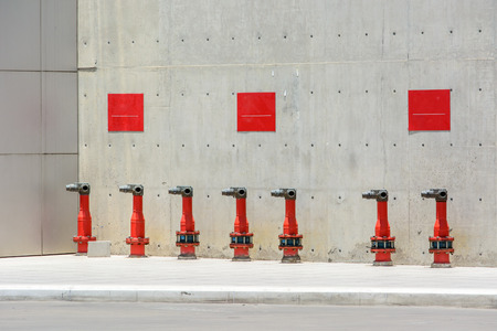 Row of fire hydrant beside buildingの写真素材