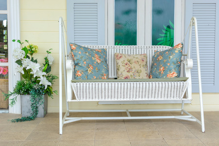 white swing bench with pillow and flowerの写真素材